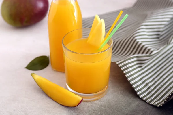 Glas en fles smakelijke mango sap op tafel — Stockfoto