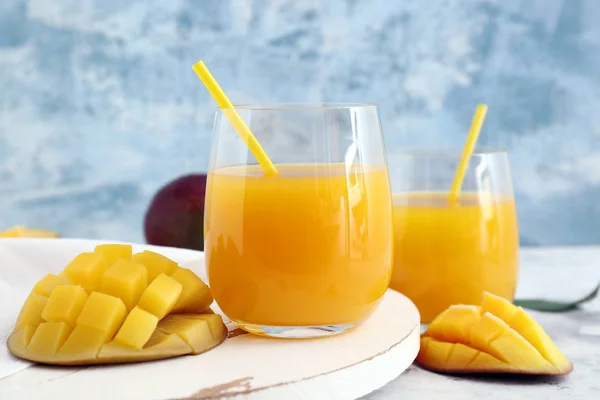 Glazen van verse mango sap op tafel — Stockfoto