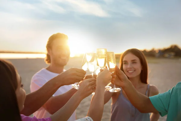 Друзі п'ють шампанське на морському пляжі — стокове фото