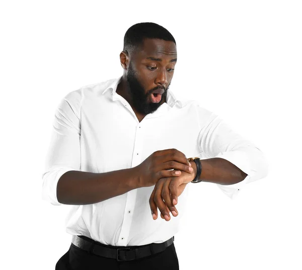 Chockad afro-amerikansk affärsman tittar på sin klocka på vit bakgrund — Stockfoto