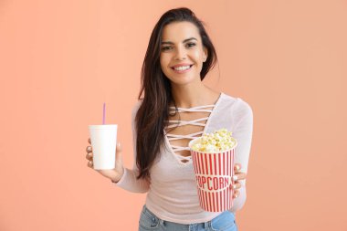 Renkli arka planda patlamış mısır ile genç kadın