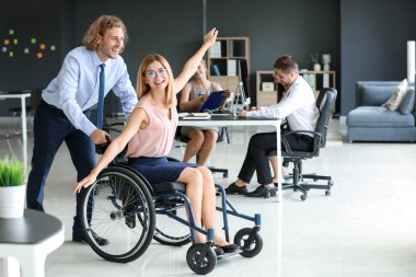 İş arkadaşı ofiste eğleniyor engelli genç kadın