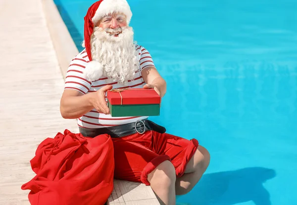Santa Claus con regalo cerca de la piscina en el complejo — Foto de Stock