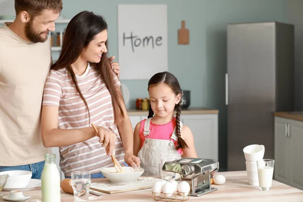 Молода сім'я готує разом на кухні — стокове фото