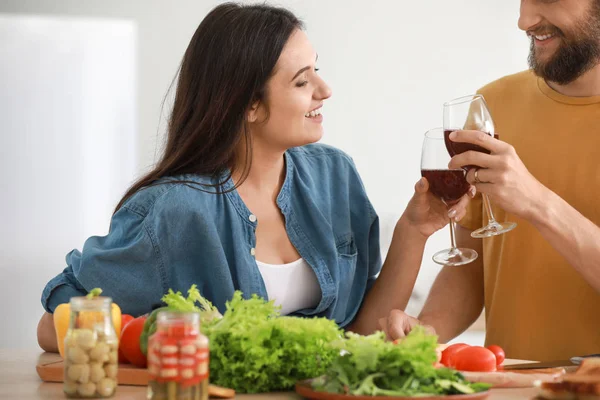 Pasangan muda minum anggur saat memasak bersama di dapur — Stok Foto