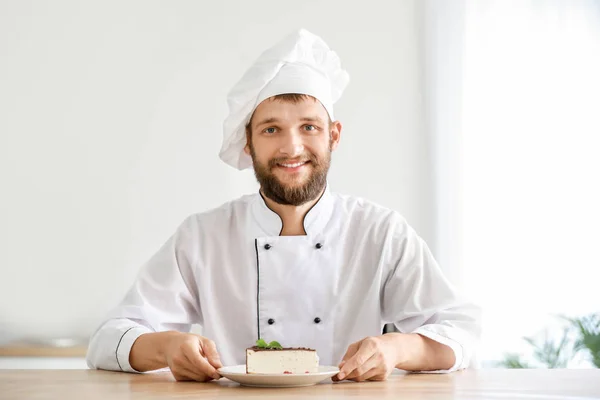 Guapo chef masculino con sabroso pastel en la cocina —  Fotos de Stock