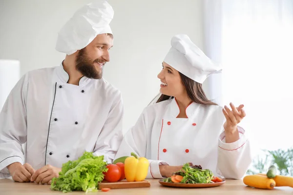 Professional chefs preparing vegetable salad in kitchen — Stock Photo, Image