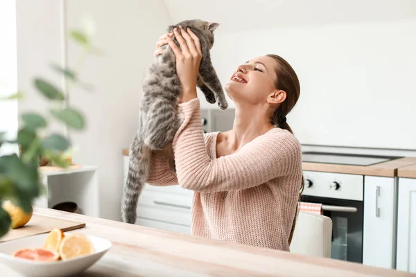 Beautiful young woman with cute cat in kitchen — Stock Photo, Image