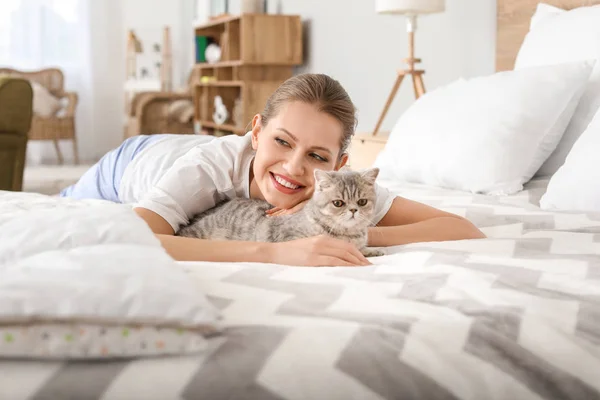 Beautiful young woman with cute cat in bedroom — Stock Photo, Image