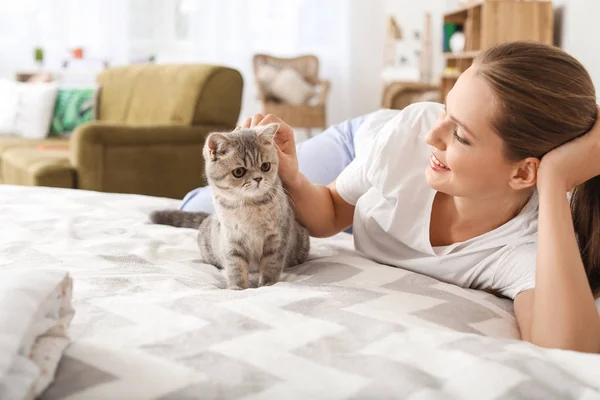 Beautiful young woman with cute cat in bedroom — Stock Photo, Image