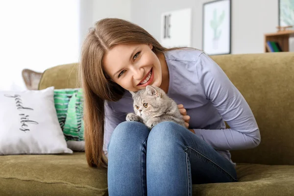 Όμορφη νεαρή γυναίκα με χαριτωμένο γάτα στο σπίτι — Φωτογραφία Αρχείου