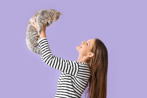 Belle jeune femme avec chat mignon sur fond de couleur — Photo