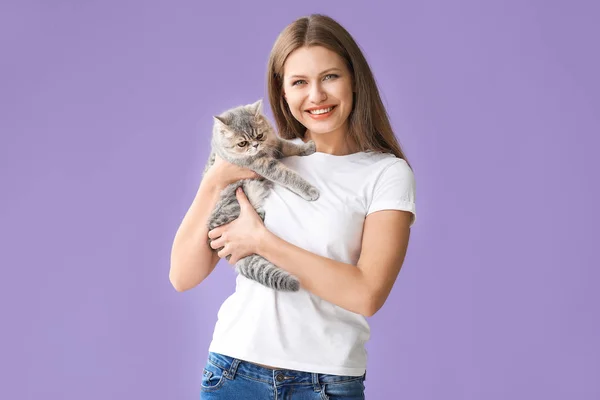 Красива молода жінка з милою кішкою на кольоровому фоні — стокове фото