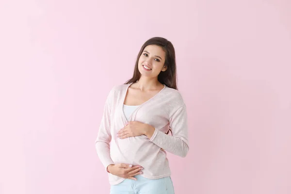 Fiatal terhes nő színes háttér — Stock Fotó