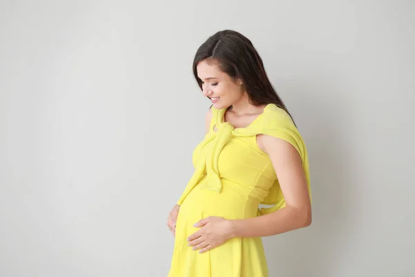 Jovem grávida no fundo de luz — Fotografia de Stock