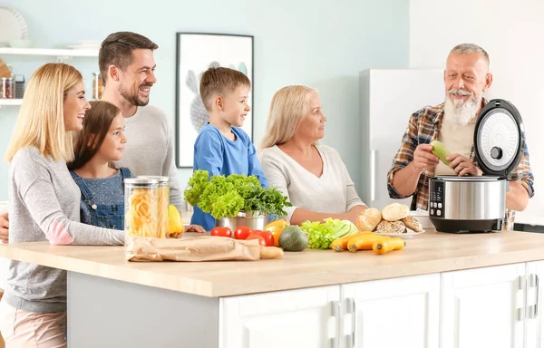 Happy family using modern multi cooker in kitchen — Stock Photo, Image