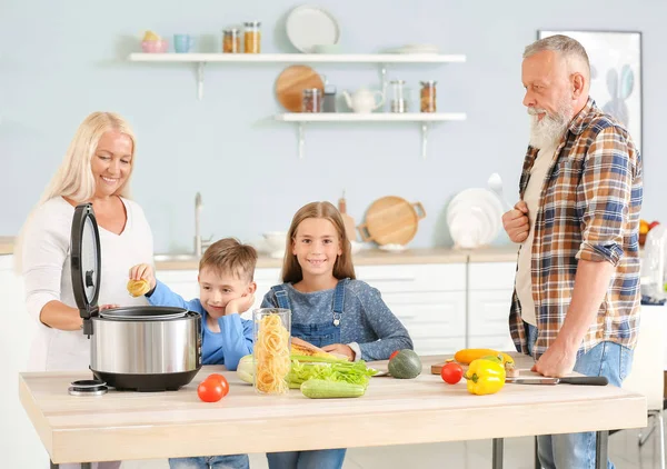 Grandparents and little children using modern multi cooker in kitchen — Stock Photo, Image