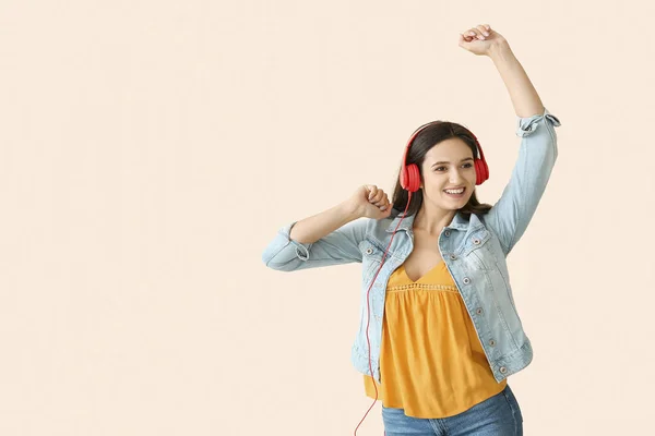 年轻女子与耳机跳舞的光背景 — 图库照片