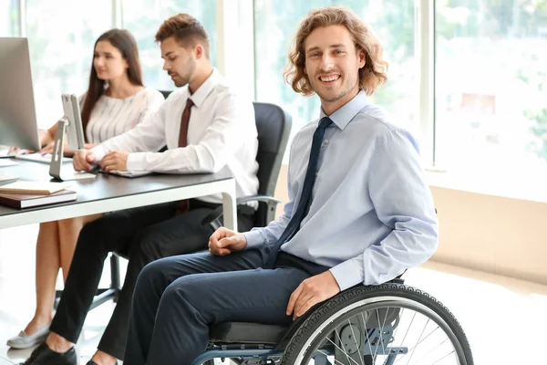 Niepełnosprawny młodzieniec z kolegami pracującymi w biurze — Zdjęcie stockowe