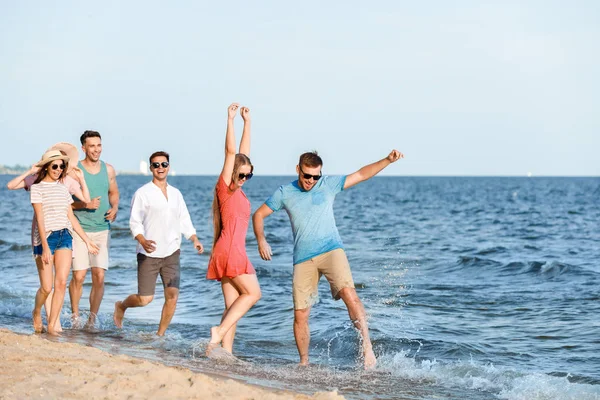 Счастливые друзья на морском пляже на курорте — стоковое фото