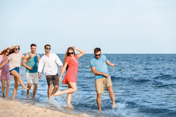 Happy friends on sea beach at resort — Stock Photo, Image