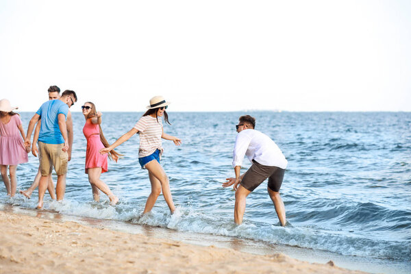 Happy friends on sea beach at resort