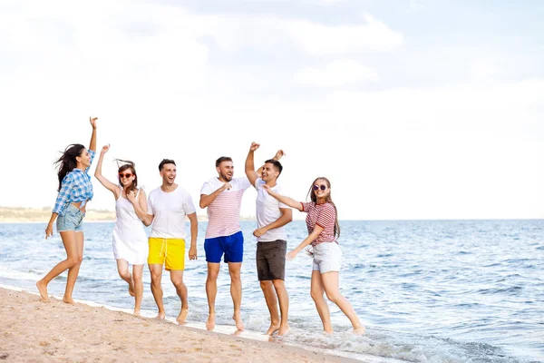 Счастливые друзья на морском пляже на курорте — стоковое фото