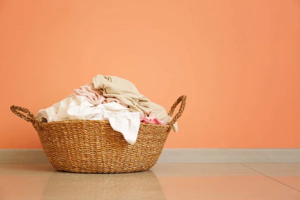 Basket with dirty laundry on floor