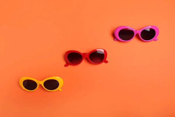 Diferentes óculos de sol elegantes no fundo de cor — Fotografia de Stock