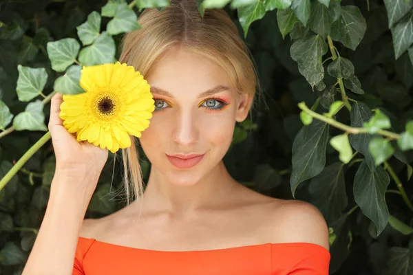 Vacker ung kvinna med Gerbera blomma utomhus — Stockfoto