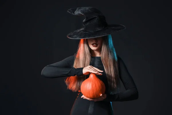 Mooie vrouw verkleed als heks voor Halloween op donkere achtergrond — Stockfoto