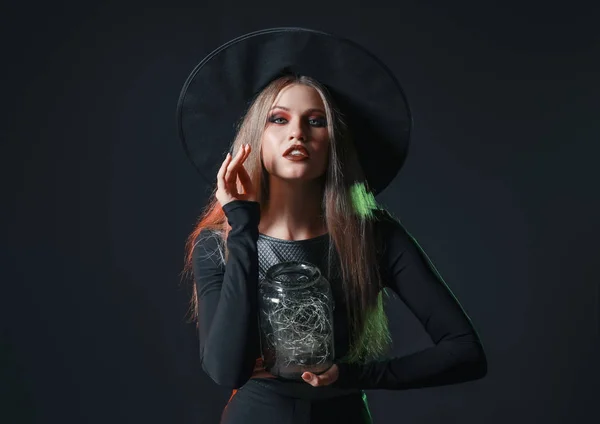 Vacker kvinna klädd som häxa för Halloween på mörk bakgrund — Stockfoto