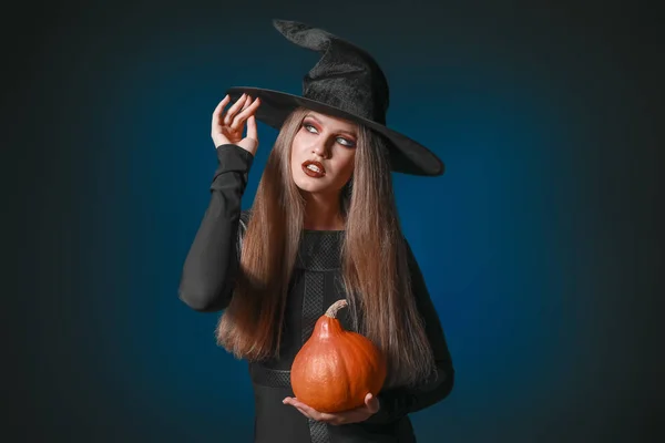 Mooie vrouw verkleed als heks voor Halloween op donkere achtergrond — Stockfoto