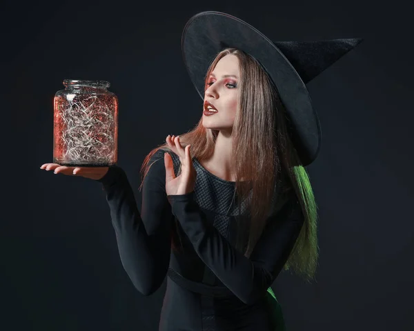 Красива жінка, одягнена як відьма для Хеллоуїна на темному тлі — стокове фото