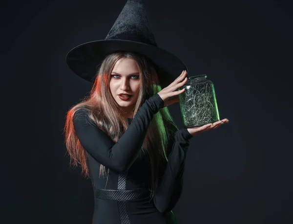 Hermosa mujer vestida de bruja para Halloween sobre fondo oscuro —  Fotos de Stock