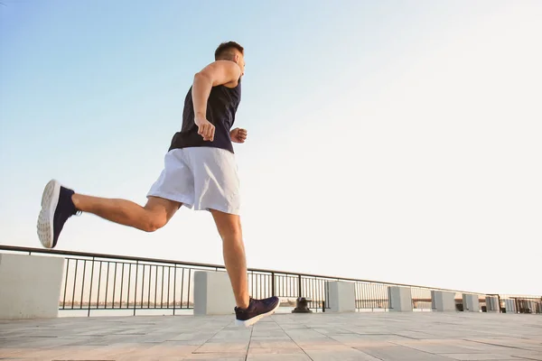 Handsome sporty man running outdoors — Stock Photo, Image