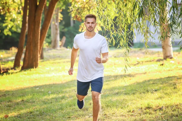 Handsome sporty man running in park — Stock Photo, Image