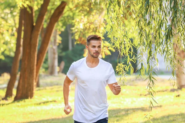 Handsome sporty man running in park — Stock Photo, Image