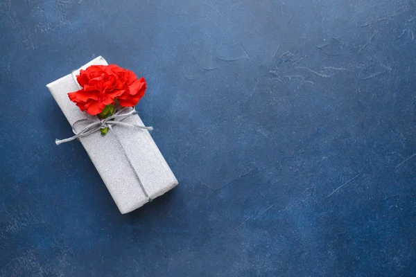 Mooie bloemen en cadeau op kleur achtergrond — Stockfoto