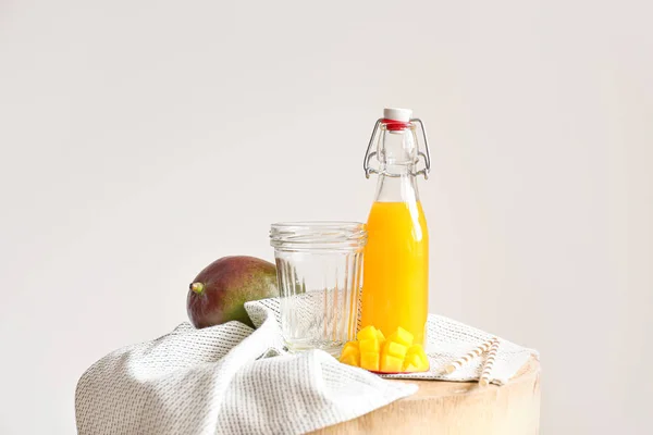 Bottle of tasty mango juice and glass on table — Stock Photo, Image