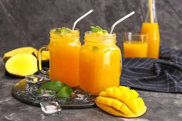 Mason jars of fresh mango juice on table — Stock Photo, Image