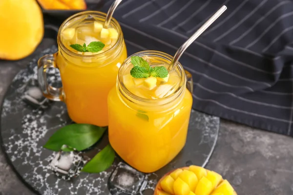 Mason jars of fresh mango juice on table — Stock Photo, Image