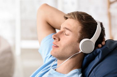 Genç adam rahatlatıcı ve evde müzik dinliyor
