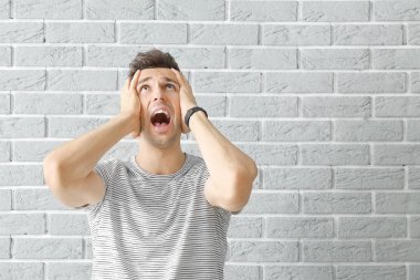 Tuğla duvara karşı stresli genç adam