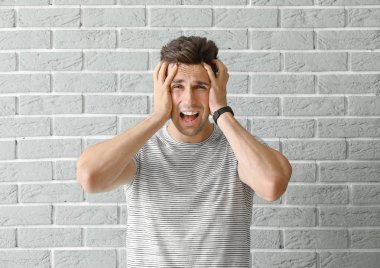 Tuğla duvara karşı stresli genç adam