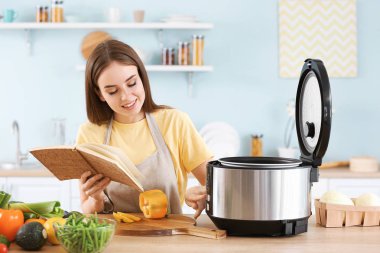 Mutfakta modern çoklu ocak kullanarak tarifi kitap ile Kadın