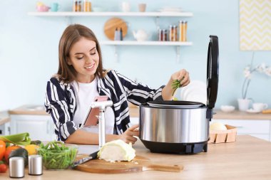 Kadın mutfakta modern çoklu ocak kullanarak