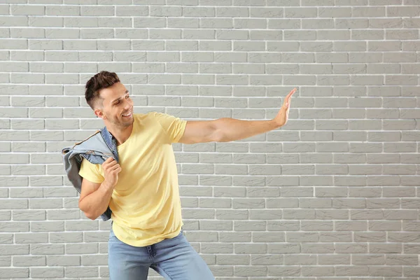 Knappe jonge man dansen tegen bakstenen muur — Stockfoto