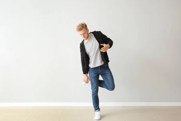 Guapo joven bailando contra la pared de luz — Foto de Stock