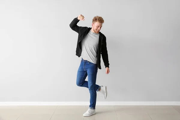 Guapo joven bailando contra la pared de luz — Foto de Stock